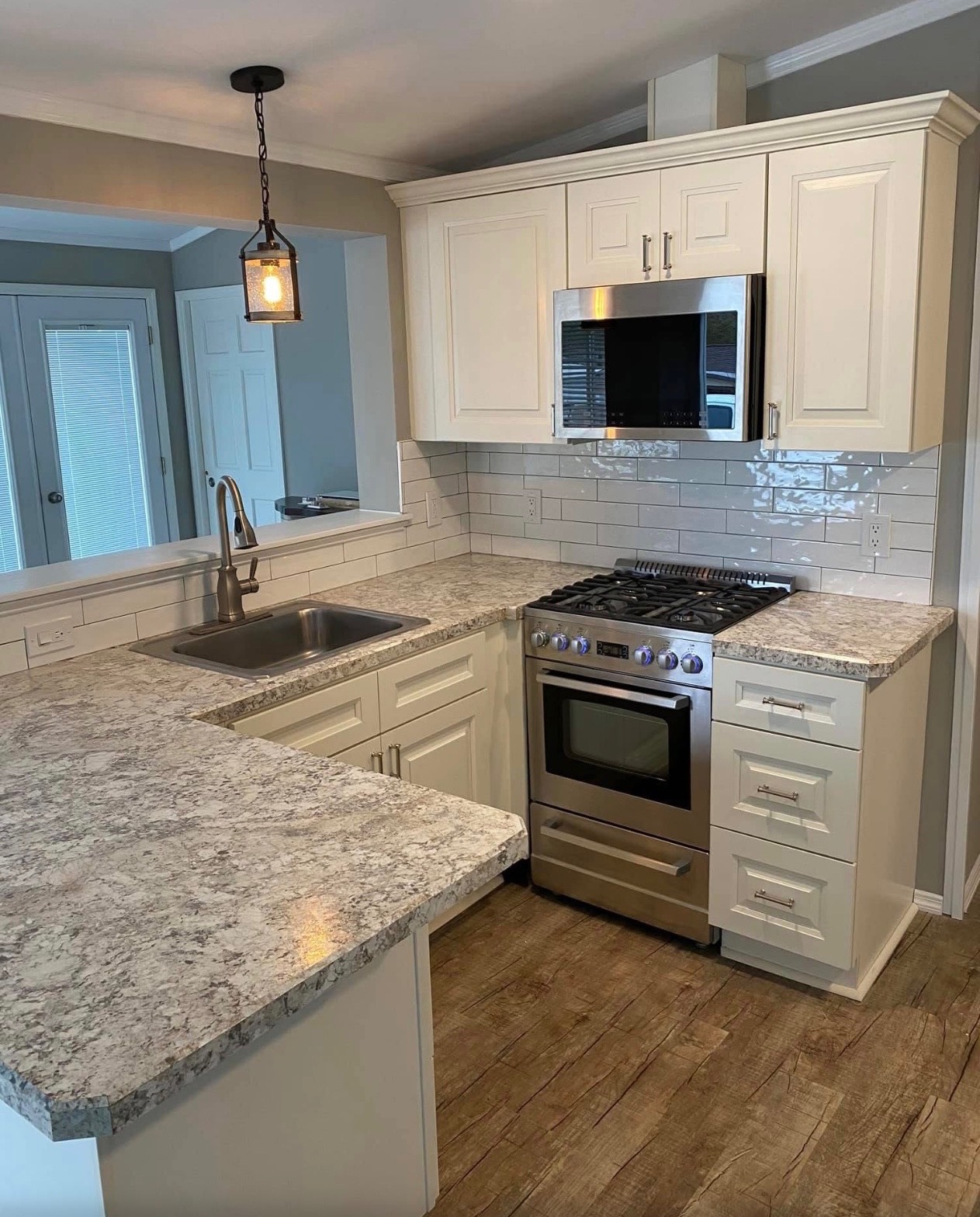 Renovated kitchen with white cabinets and granite counters